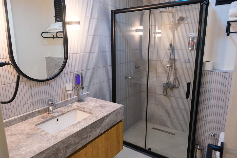 Banyo: cam duşakabin ve mermer lavabo